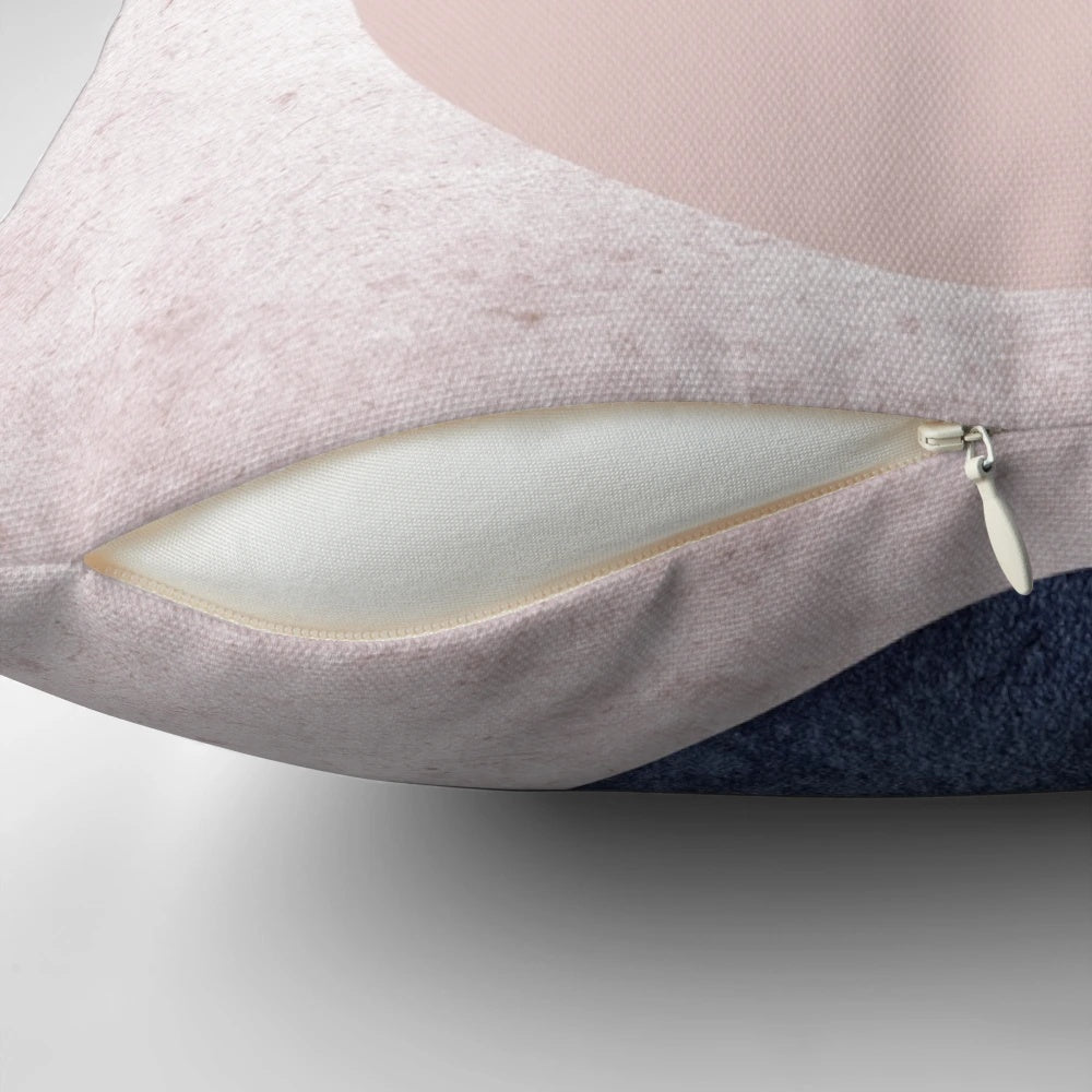 Overlapping circles pillow in pastel pink and navy blue, featuring a minimalist geometric design.
