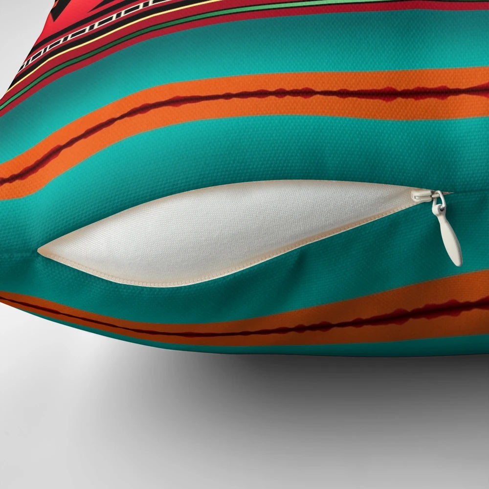 A colorful pillow featuring a Navajo-inspired geometric pattern in teal, orange, and neutral tones.