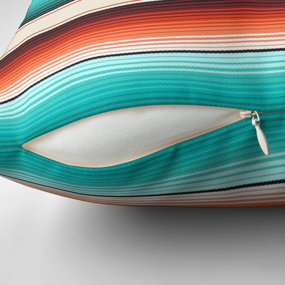 Decorative throw pillow featuring a southwest-inspired design with navajo white, turquoise, and burnt orange stripes