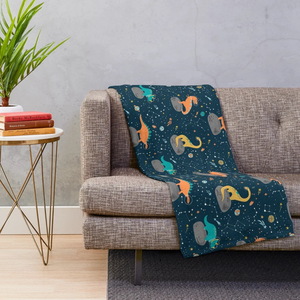 Plush dinosaur blanket with asteroid and star constellation pattern