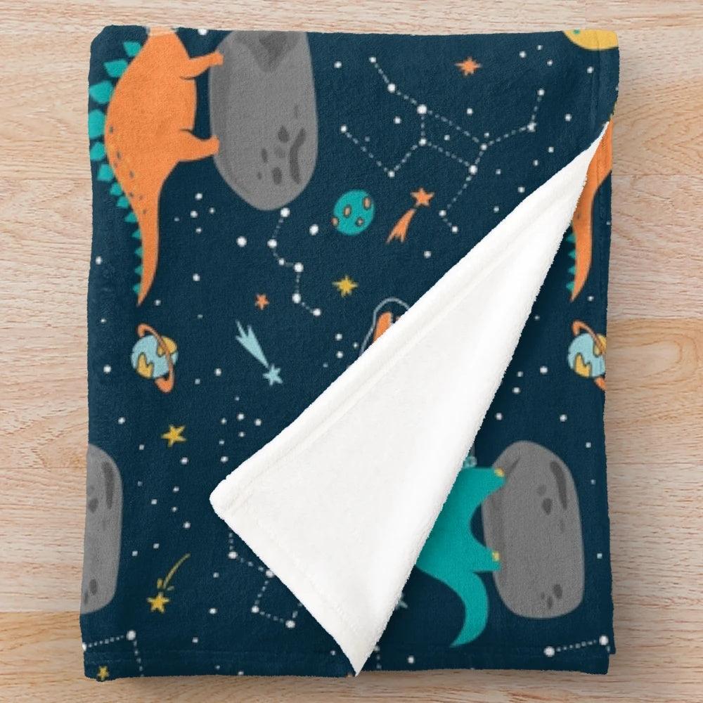 Plush dinosaur blanket with asteroid and star constellation pattern