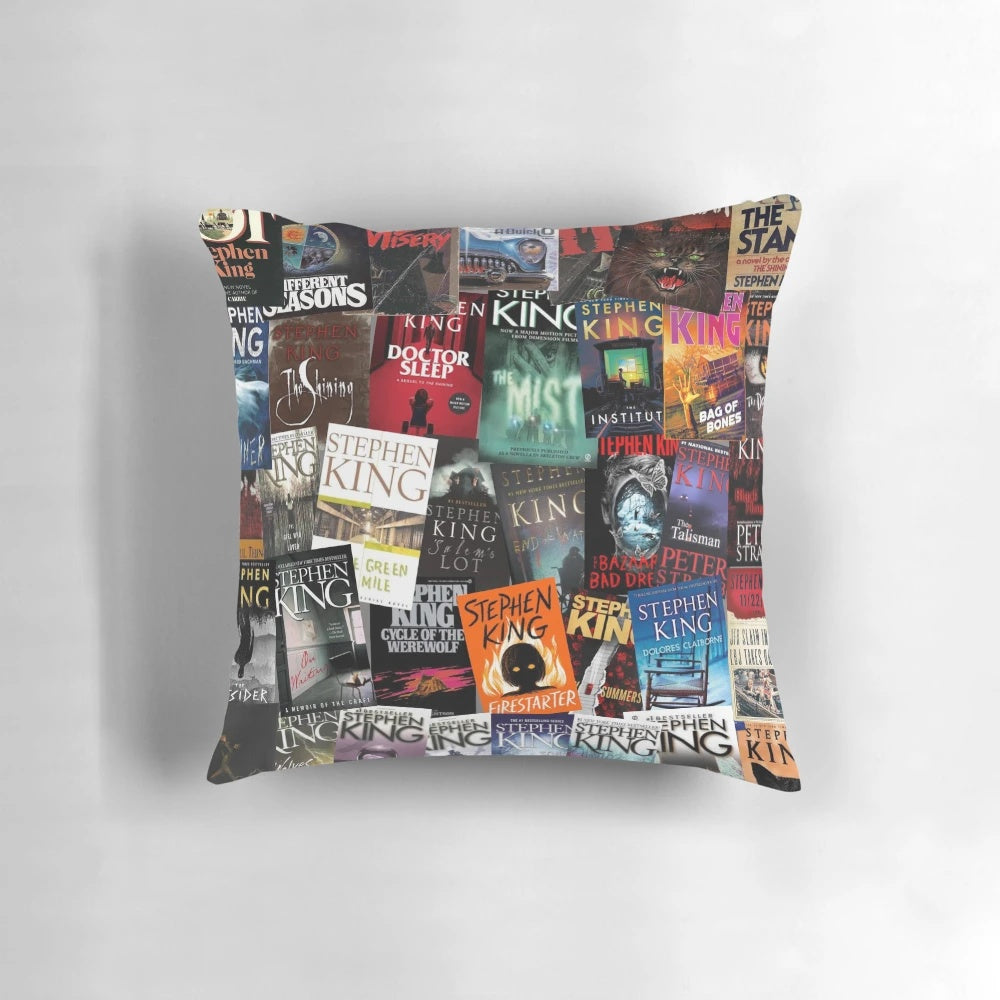 A decorative pillow featuring various horror book covers, including works by Stephen King such as Carrie, The Dark Tower, and IT.