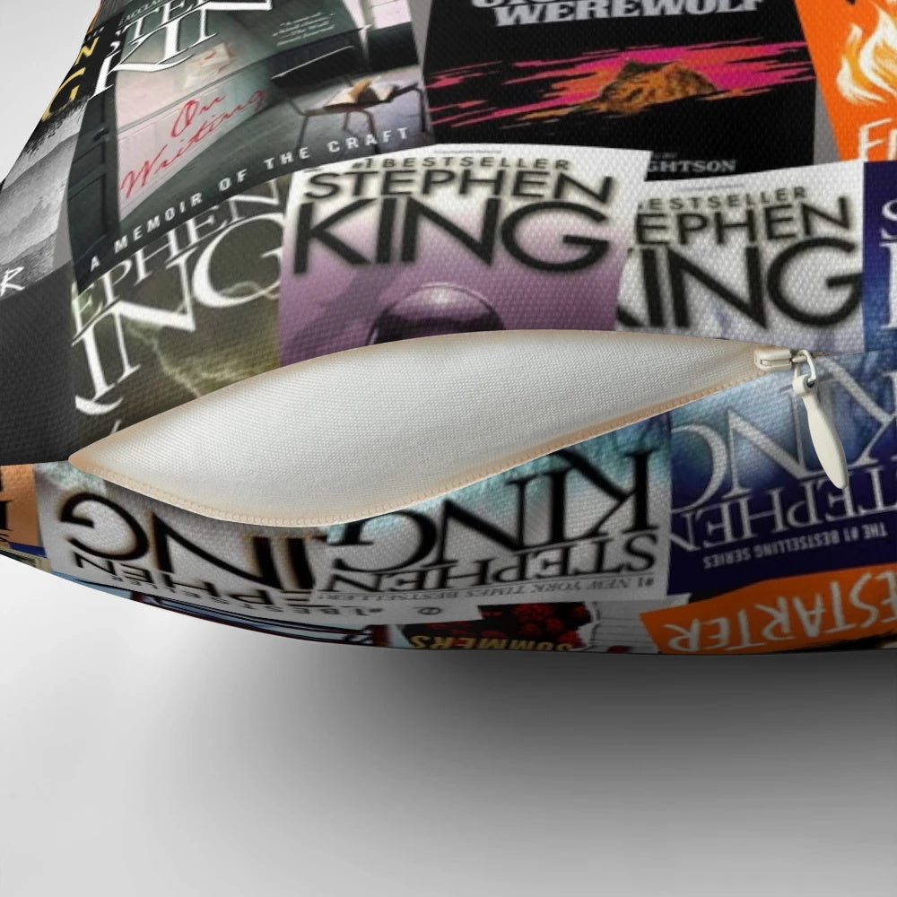 A decorative pillow featuring various horror book covers, including works by Stephen King such as Carrie, The Dark Tower, and IT.