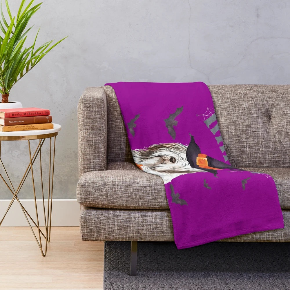 Bearded collie dog in a Halloween costume on a plush blanket