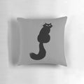 Plush black cat pillow with long hair and side-eye expression, perfect for Halloween and home decor.