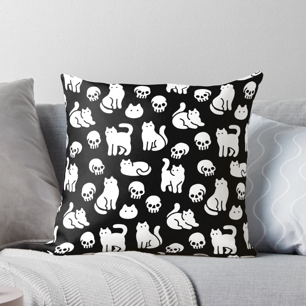 Decorative pillow featuring a pattern of cute cats and skulls, perfect for Halloween and spooky home decor