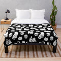 Plush blanket with cats and skulls pattern