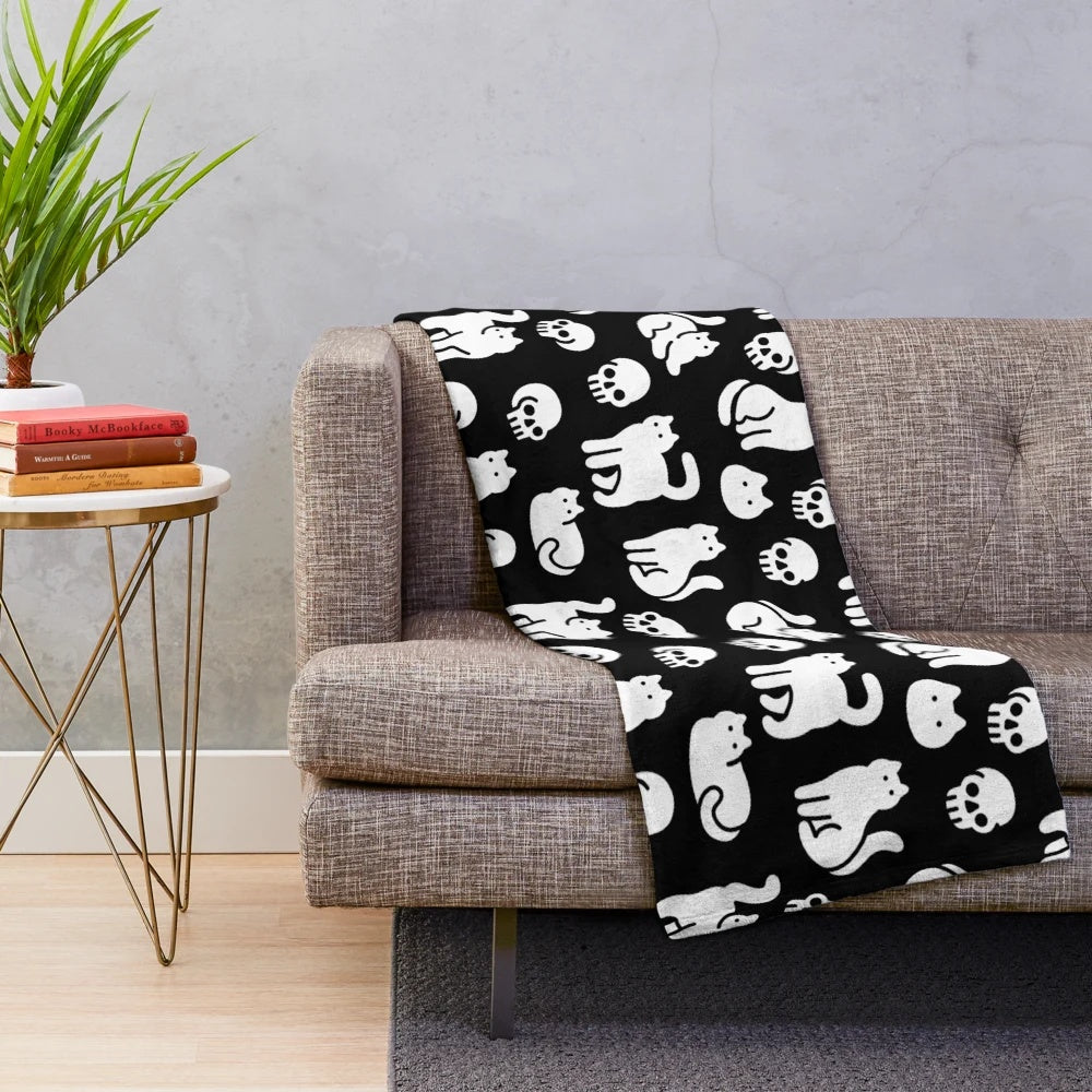 Plush blanket with cats and skulls pattern