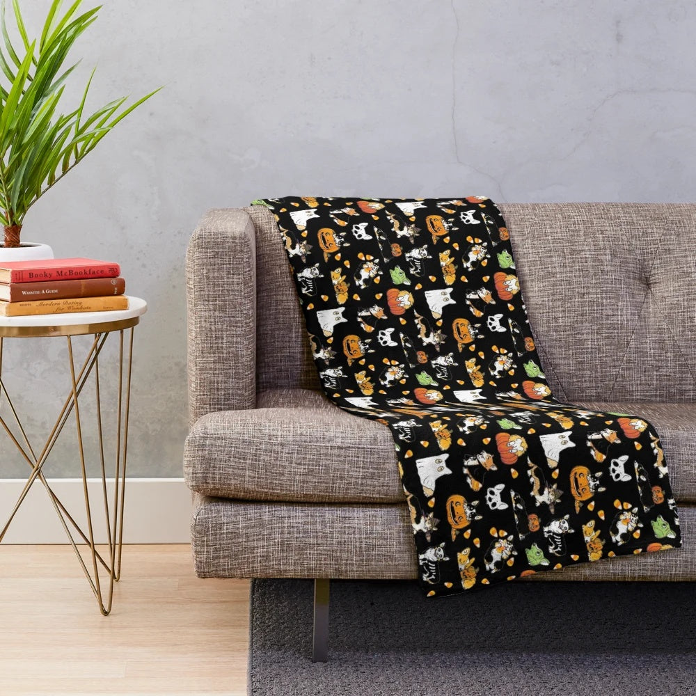 Corgi wearing a Halloween costume on a black plush blanket
