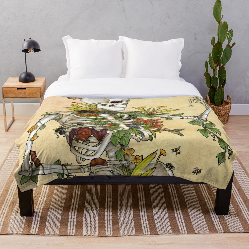 Plush blanket featuring a skeleton design with botanical elements including flowers and plants