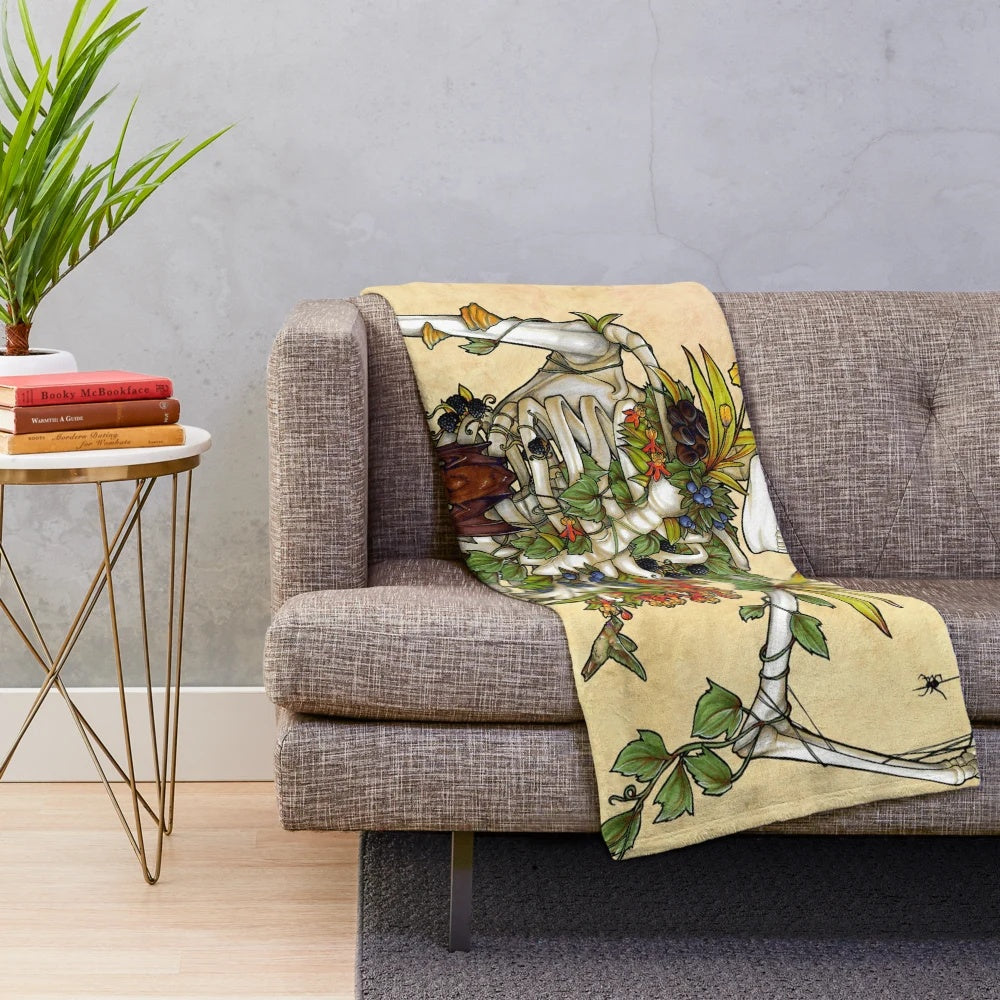 Plush blanket featuring a skeleton design with botanical elements including flowers and plants