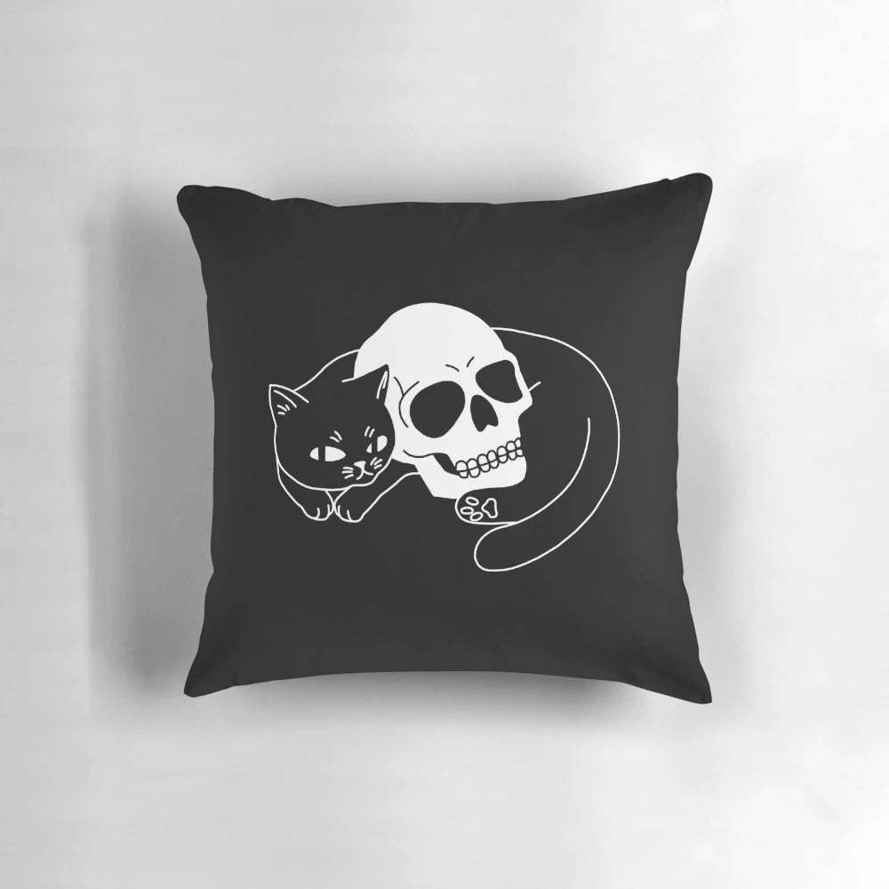 A black cat pillow with a spooky, gothic skull design