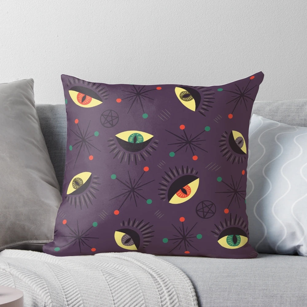 Decorative witch-themed pillow with a retro pattern featuring reptile and ghost eyes in shades of purple and black for a spooky, Halloween vibe.