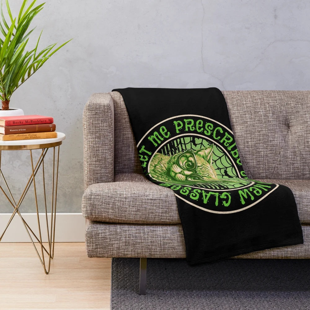 Optometrist plush blanket with spooky halloween elements like cats, bats, and spider webs