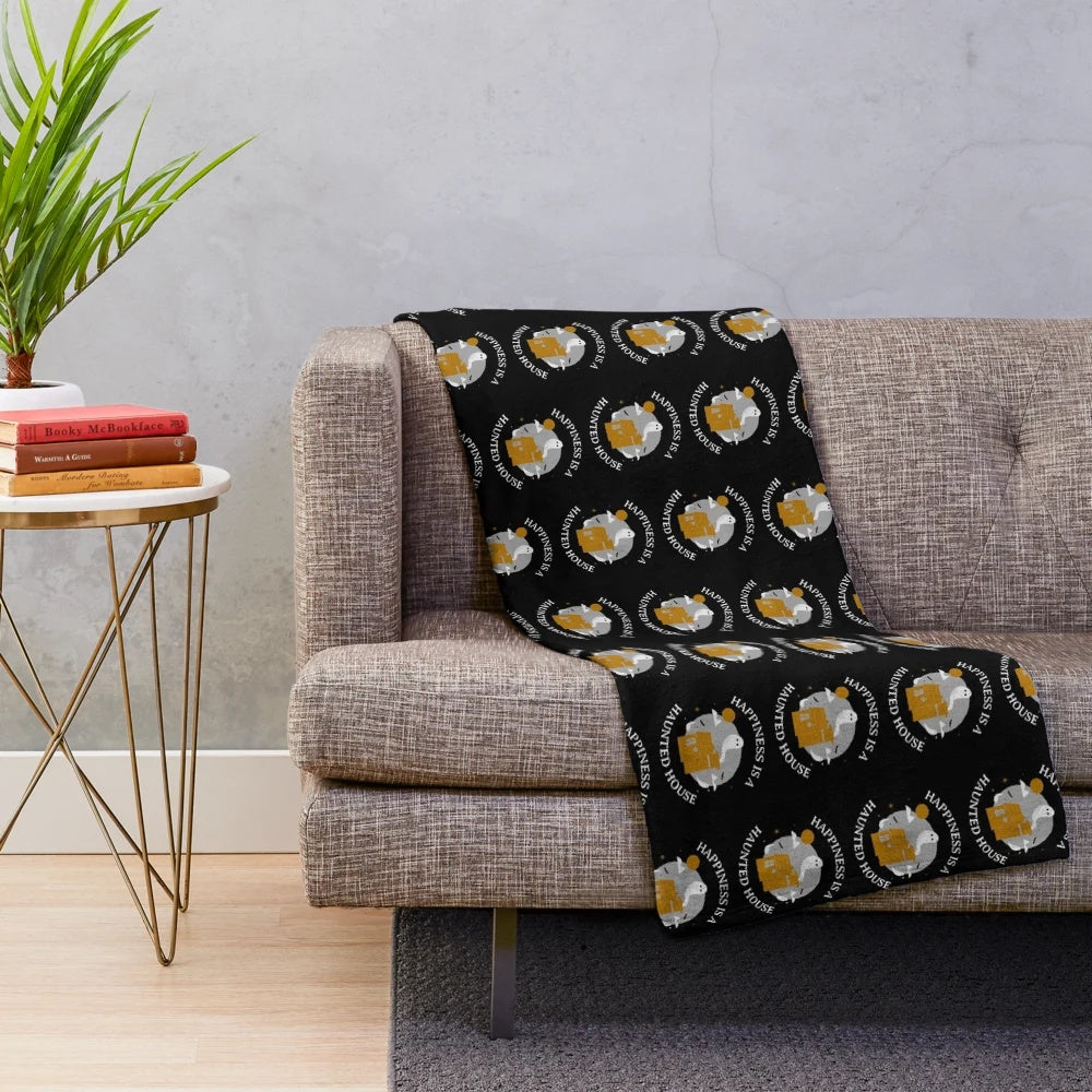 Haunted house plush blanket on a bed with pumpkins and autumn leaves
