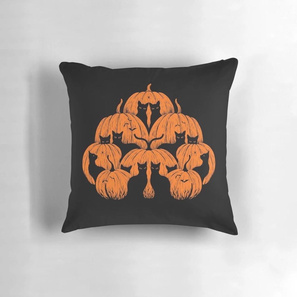 A whimsical pumpkin-shaped cat pillow in black, white, and orange for cozy, festive home decor.