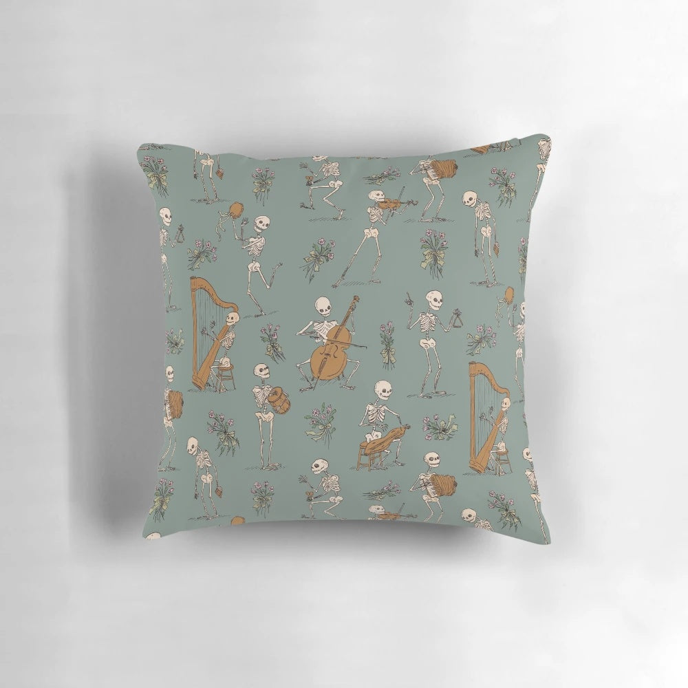 A decorative pillow featuring a skeleton orchestra with various musical instruments like harp, dulcimer, spoons, and more.