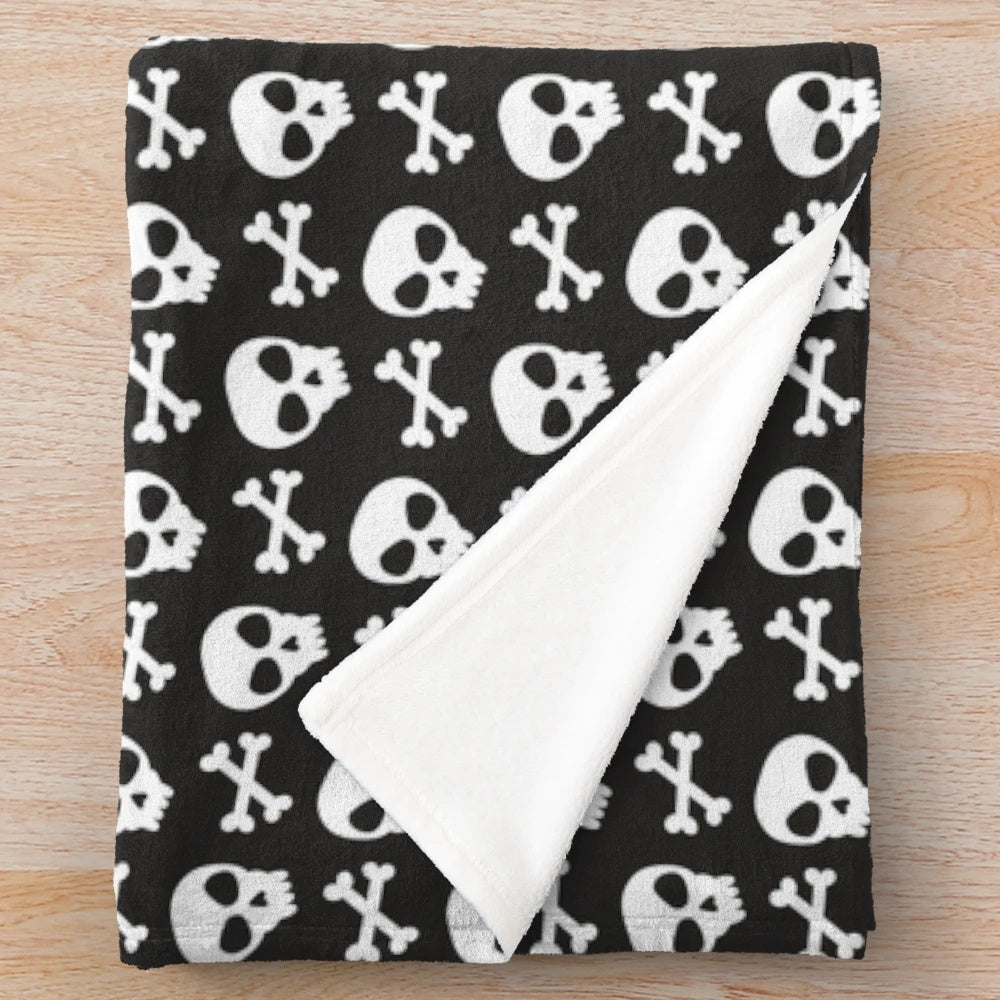 Spooky skulls and crossbones design on a black plush blanket