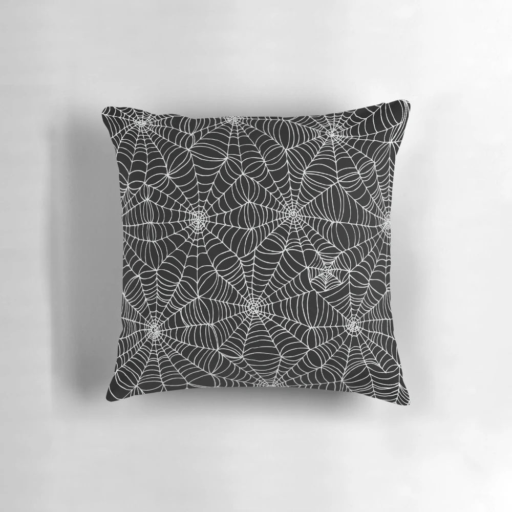 A black and white pillow featuring a detailed spider web pattern, perfect for Halloween and horror-themed decor.