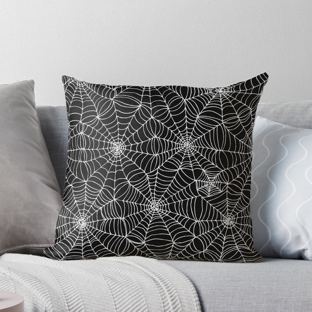 A black and white pillow featuring a detailed spider web pattern, perfect for Halloween and horror-themed decor.