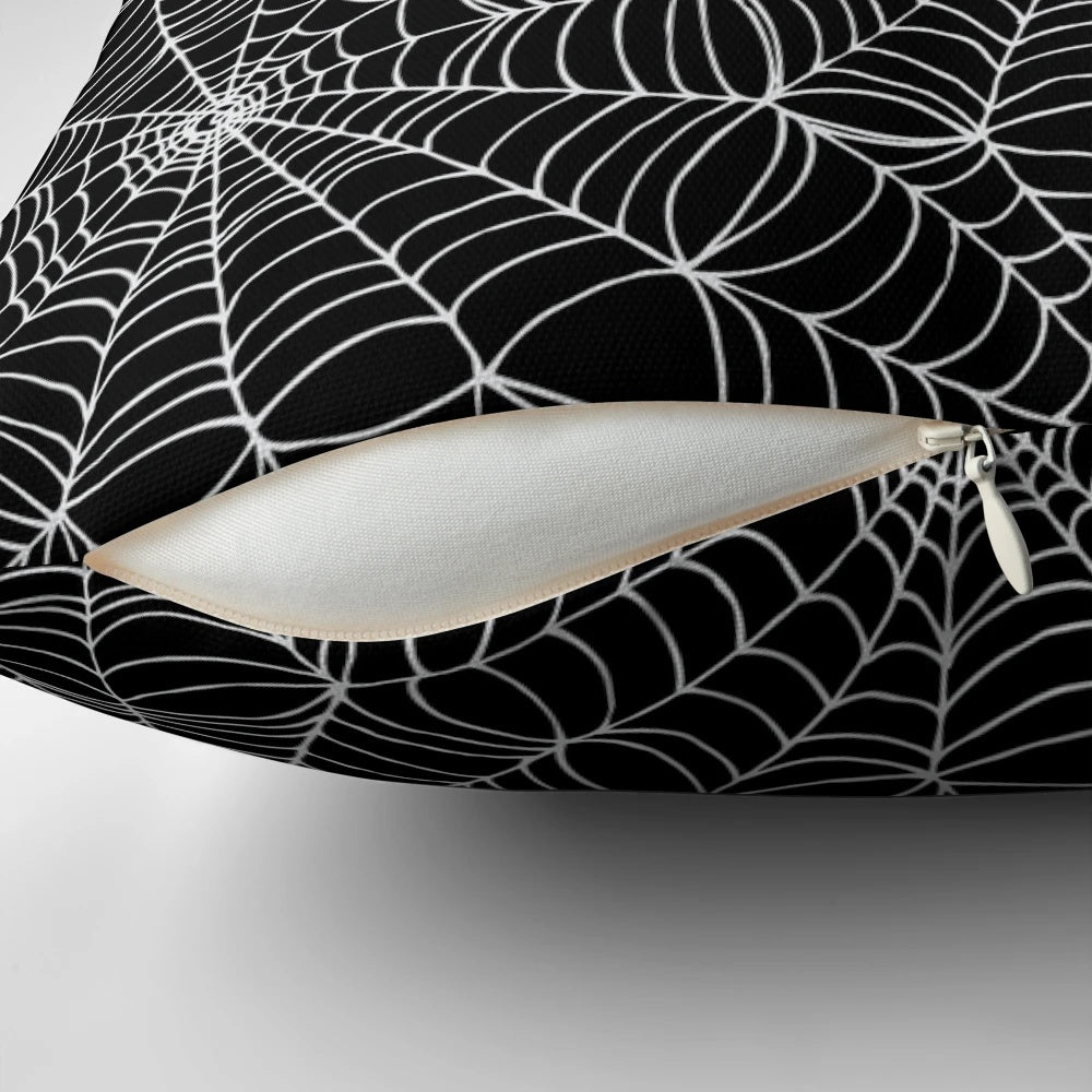 A black and white pillow featuring a detailed spider web pattern, perfect for Halloween and horror-themed decor.