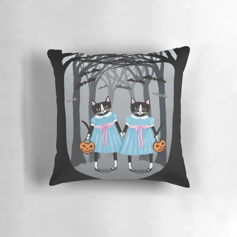 Image of a Halloween-themed pillow with two tuxedo cats in a spooky forest setting