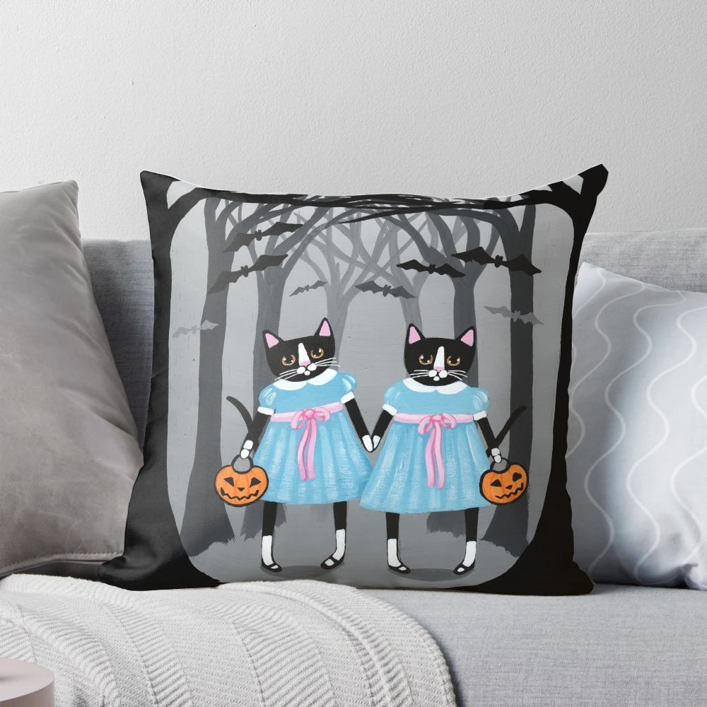 Image of a Halloween-themed pillow with two tuxedo cats in a spooky forest setting