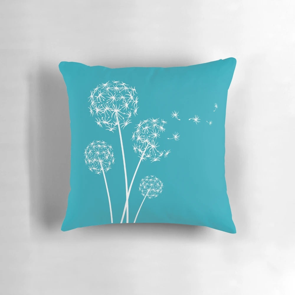 Dark turquoise dandelion flower pillow with soft, fluffy petals and seeds blowing in the wind