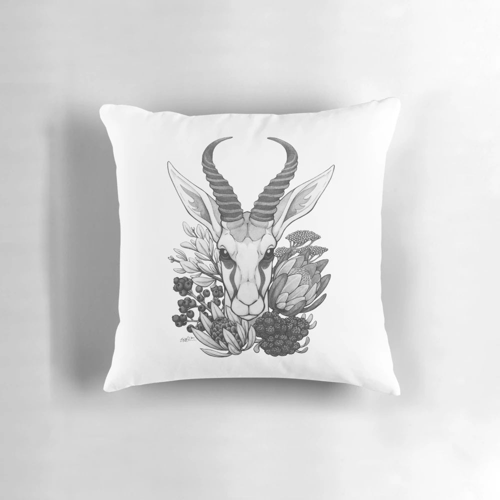 A black and white throw pillow featuring the silhouette of a springbok antelope surrounded by fynbos flowers, perfect for South African-inspired home decor.