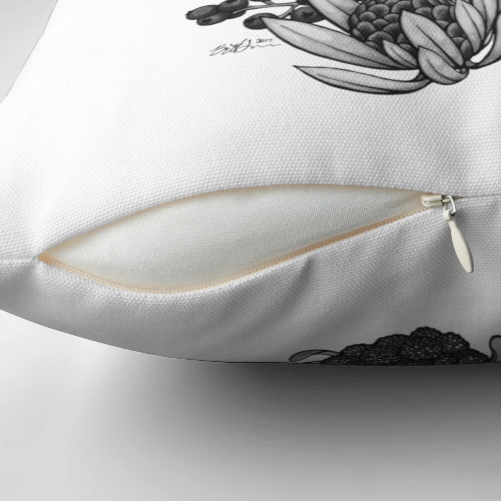 A black and white throw pillow featuring the silhouette of a springbok antelope surrounded by fynbos flowers, perfect for South African-inspired home decor.