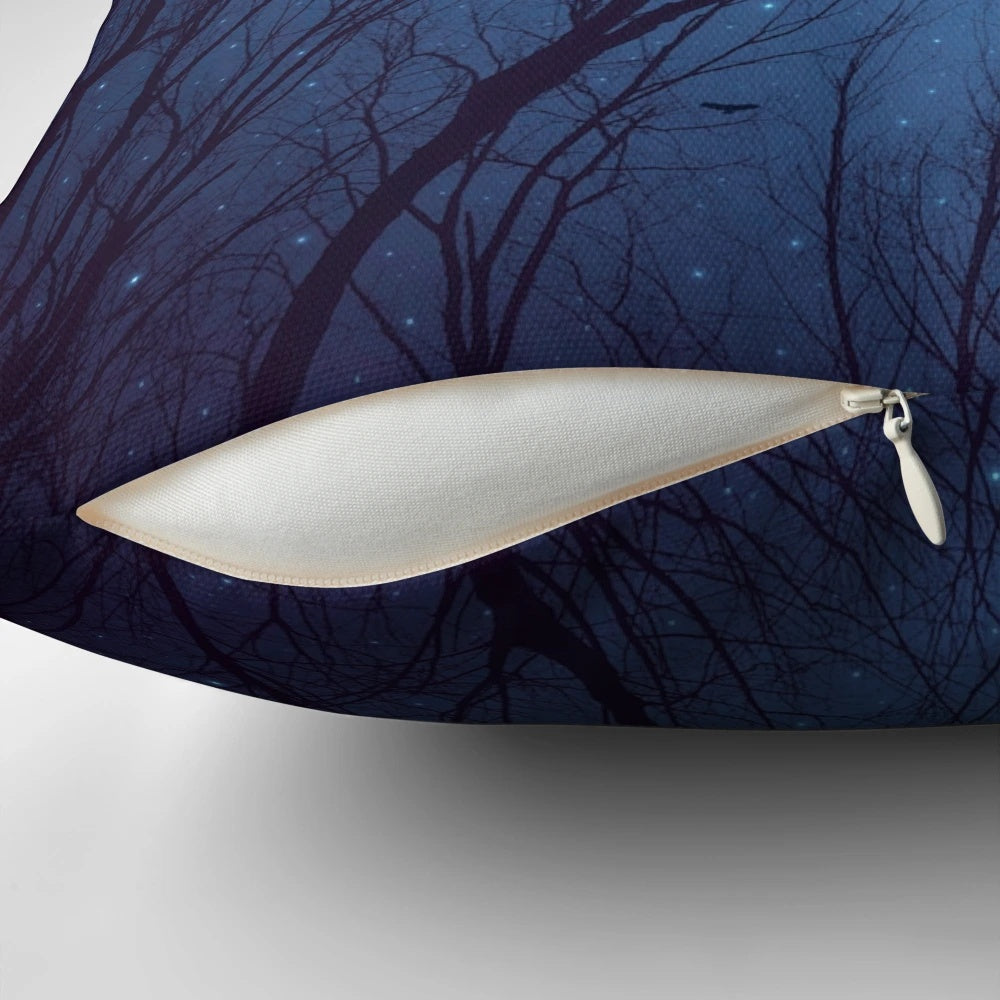 A decorative throw pillow featuring a print of a night sky with a silhouette of trees and a galaxy of stars in shades of indigo blue.