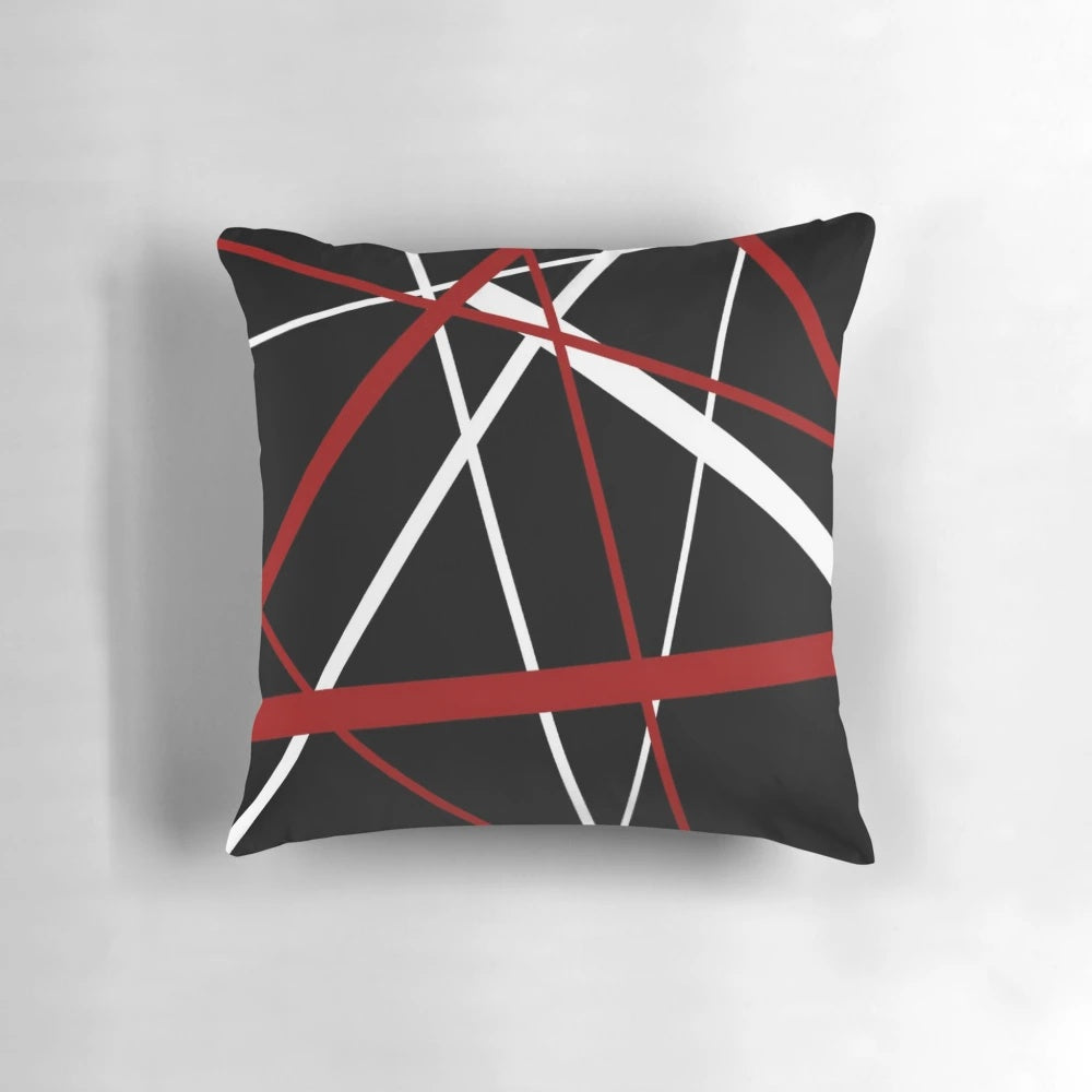 Pillow featuring a bold, abstract pattern of intersecting red and white lines on a black background.