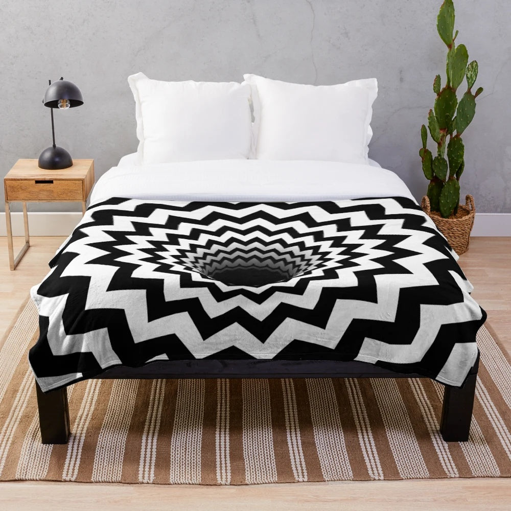 Optical illusion black and white plush blanket with hypnotic chevron pattern