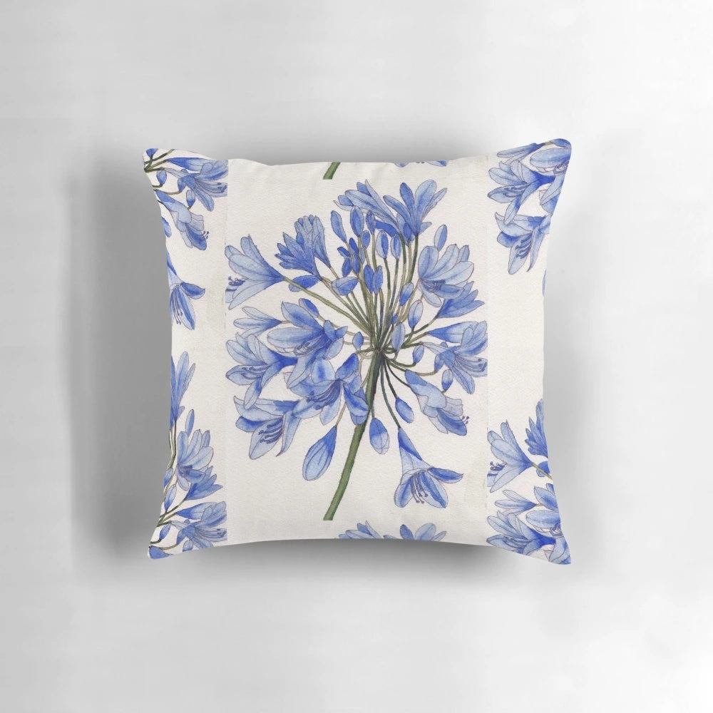 Vibrant watercolor painting of blue agapanthus flowers on a decorative pillow