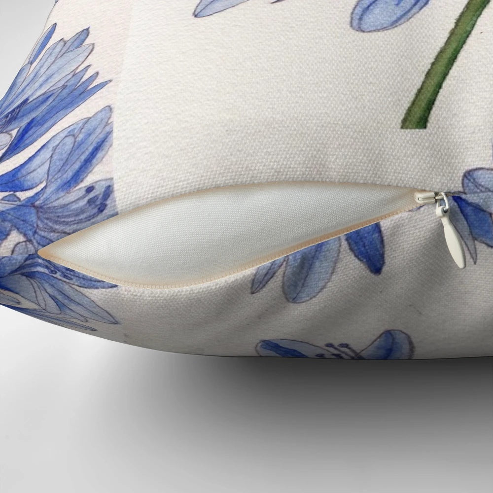 Vibrant watercolor painting of blue agapanthus flowers on a decorative pillow