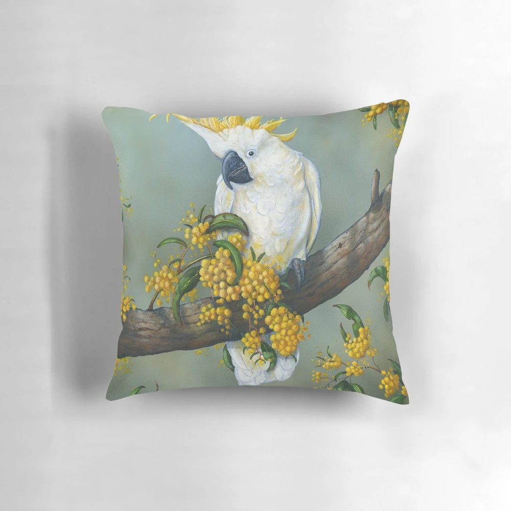 Closeup image of a beautiful Australian white cockatoo perched on a decorative pillow