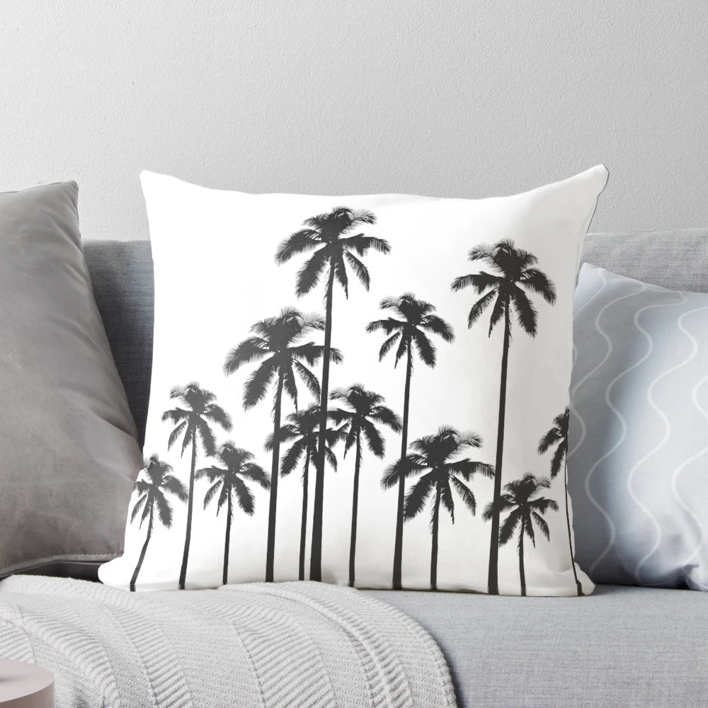 A stylish black and white throw pillow featuring a tropical palm tree pattern.