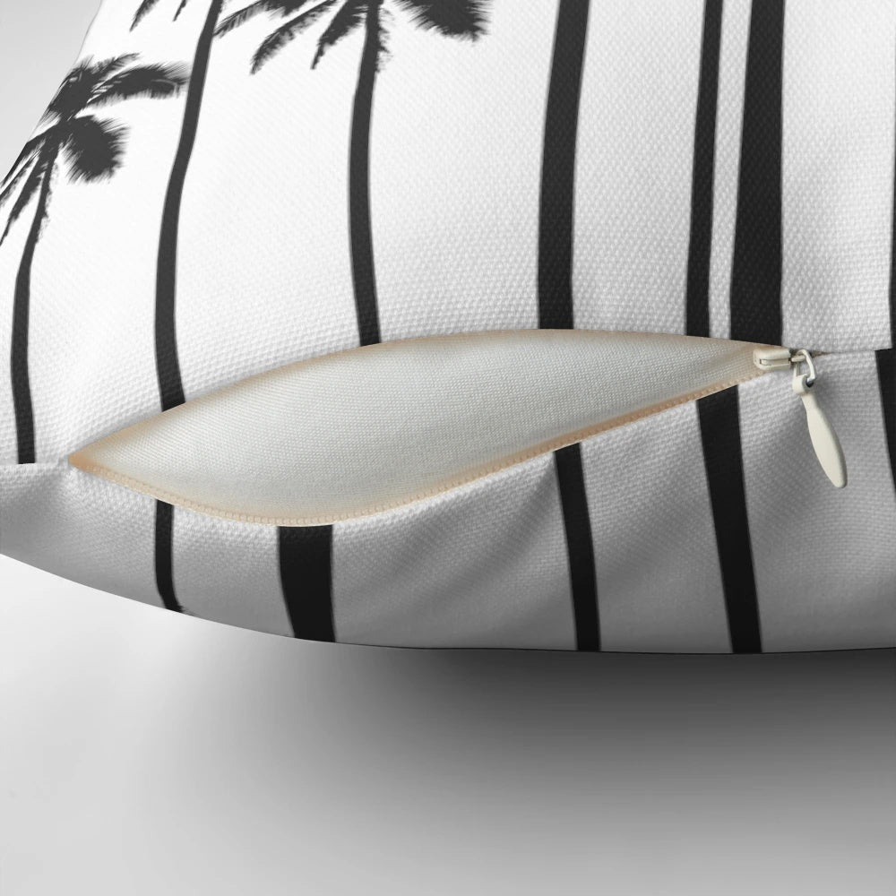 A stylish black and white throw pillow featuring a tropical palm tree pattern.