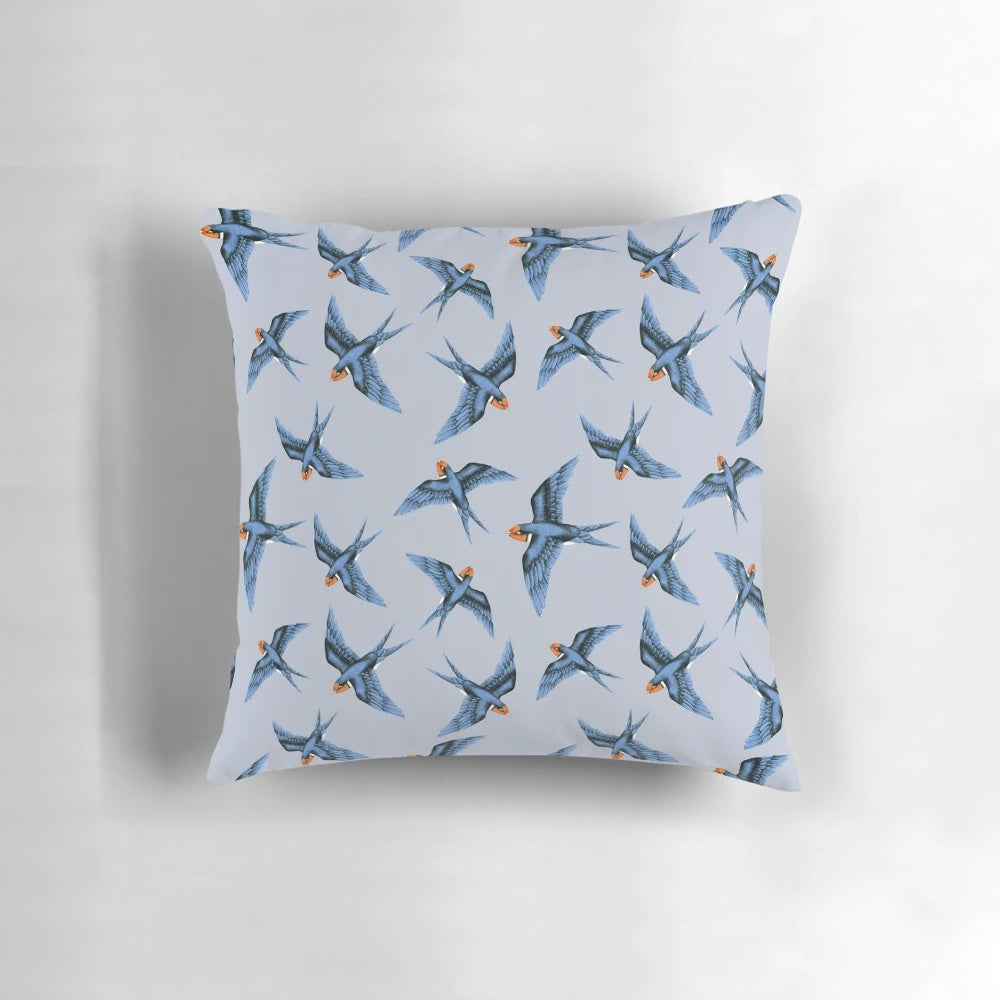 Decorative pillow featuring a blue swallow bird in flight on a stormy grey background