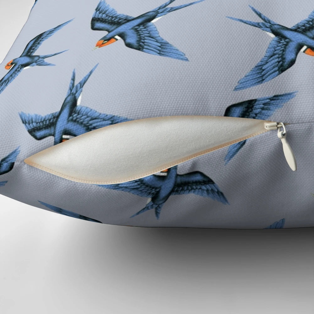 Decorative pillow featuring a blue swallow bird in flight on a stormy grey background