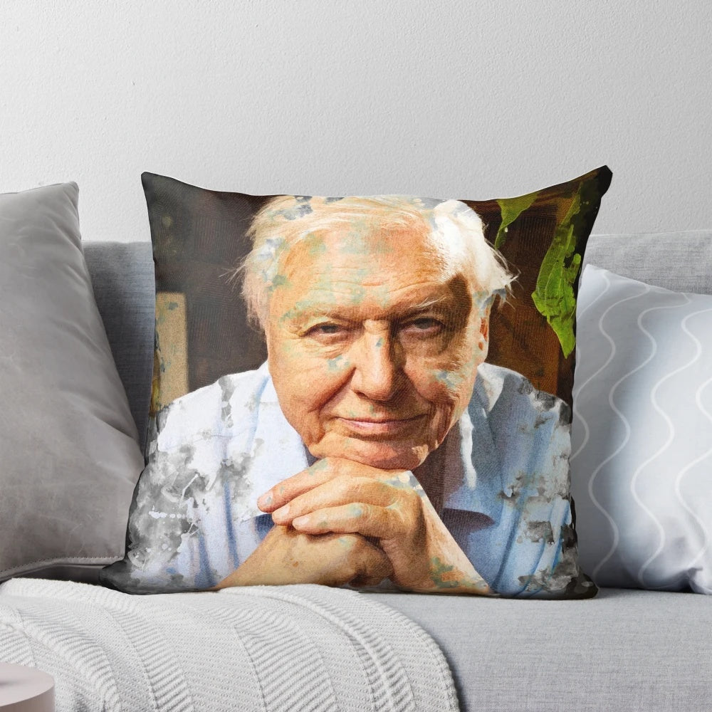 A decorative throw pillow featuring a watercolor portrait of the renowned naturalist David Attenborough