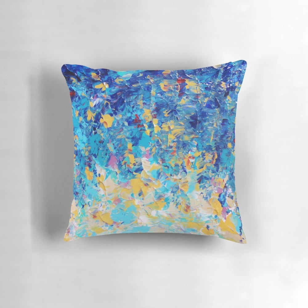 A vibrant, abstract nature-inspired pillow in shades of royal blue, navy, and turquoise.