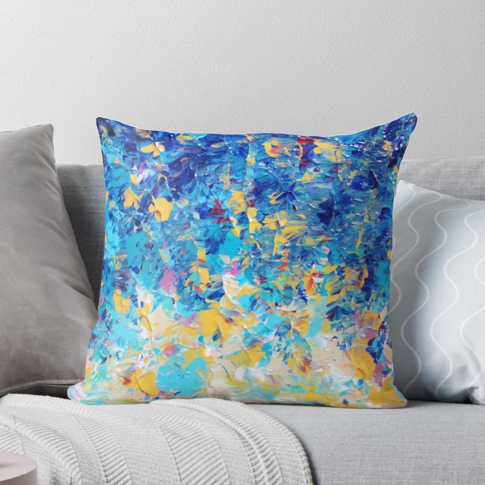 A vibrant, abstract nature-inspired pillow in shades of royal blue, navy, and turquoise.