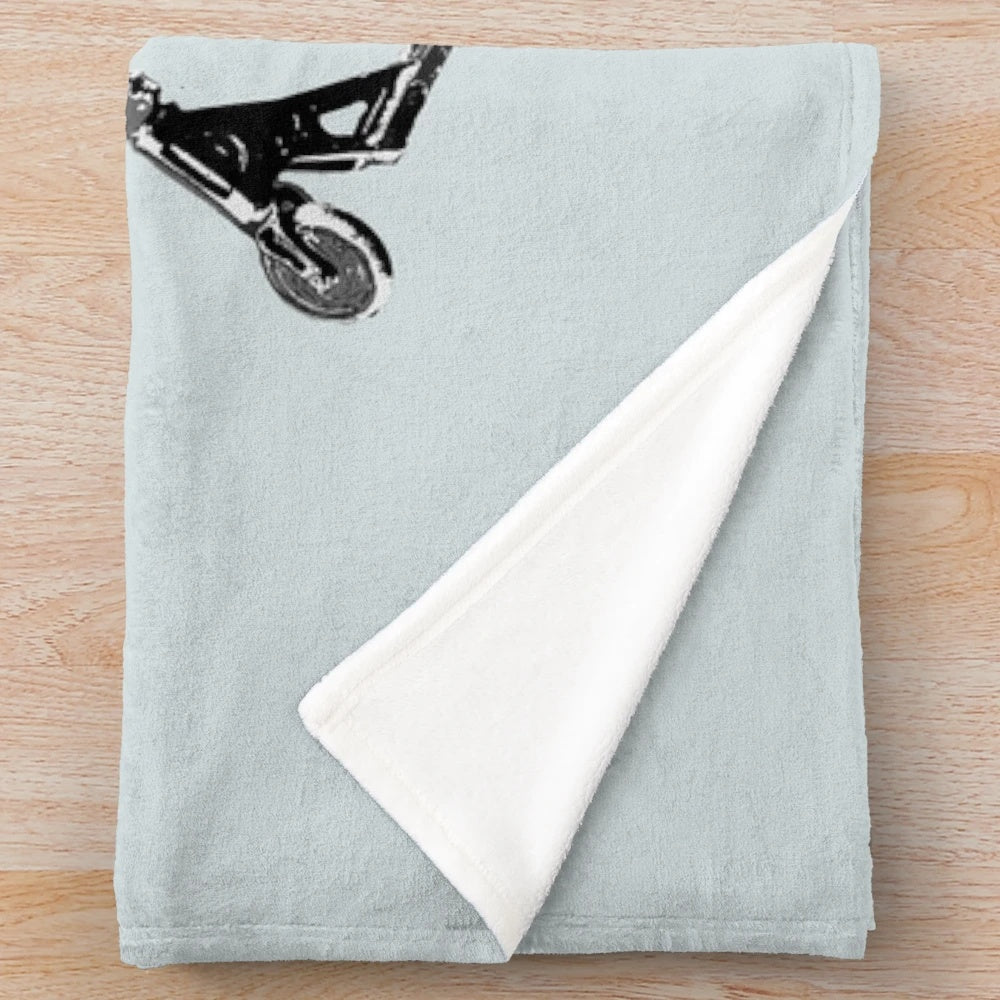 Plush blanket featuring a scooter performing a mid-air turn stunt