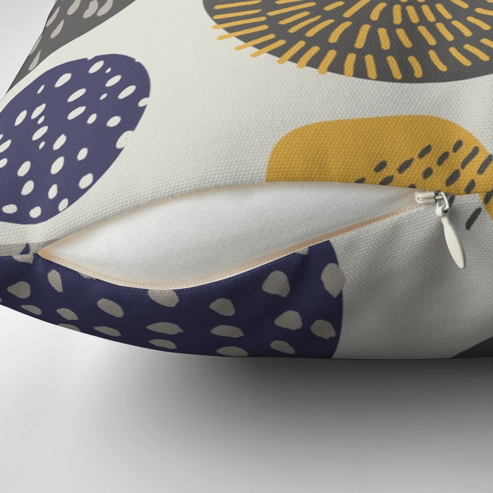 An abstract pattern of interlocking circles in navy and mustard colors on a decorative pillow.