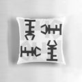 Decorative throw pillow featuring an authentic African symbol design in black and white.