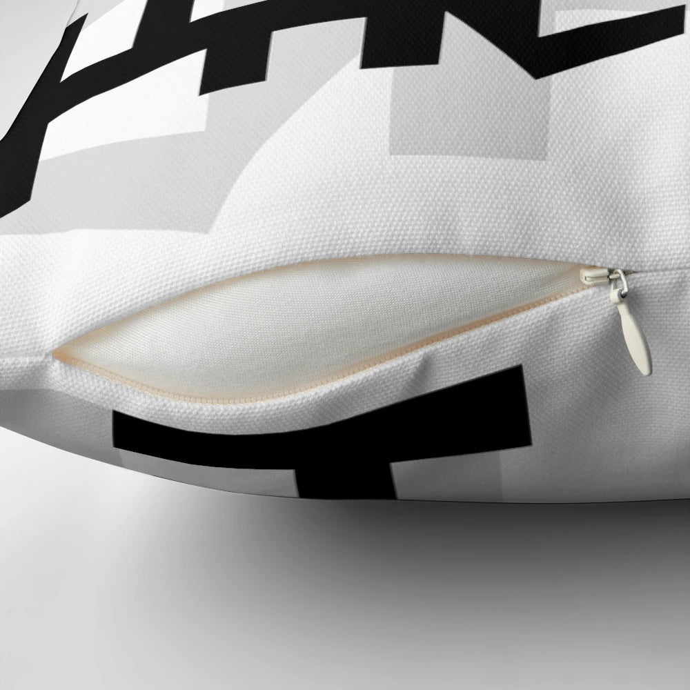 Decorative throw pillow featuring an authentic African symbol design in black and white.
