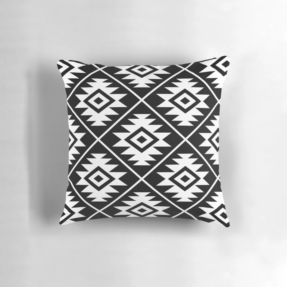 Decorative black and white Aztec tribal pattern throw pillow with geometric shapes and symbols