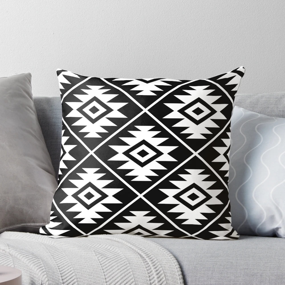 Decorative black and white Aztec tribal pattern throw pillow with geometric shapes and symbols