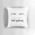 A decorative throw pillow featuring a minimalist illustration of a woman's face and stylized eyebrows.